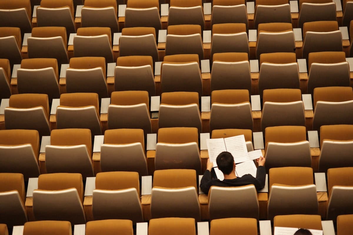 A single student reading in an otherwise empty lecture theater.
